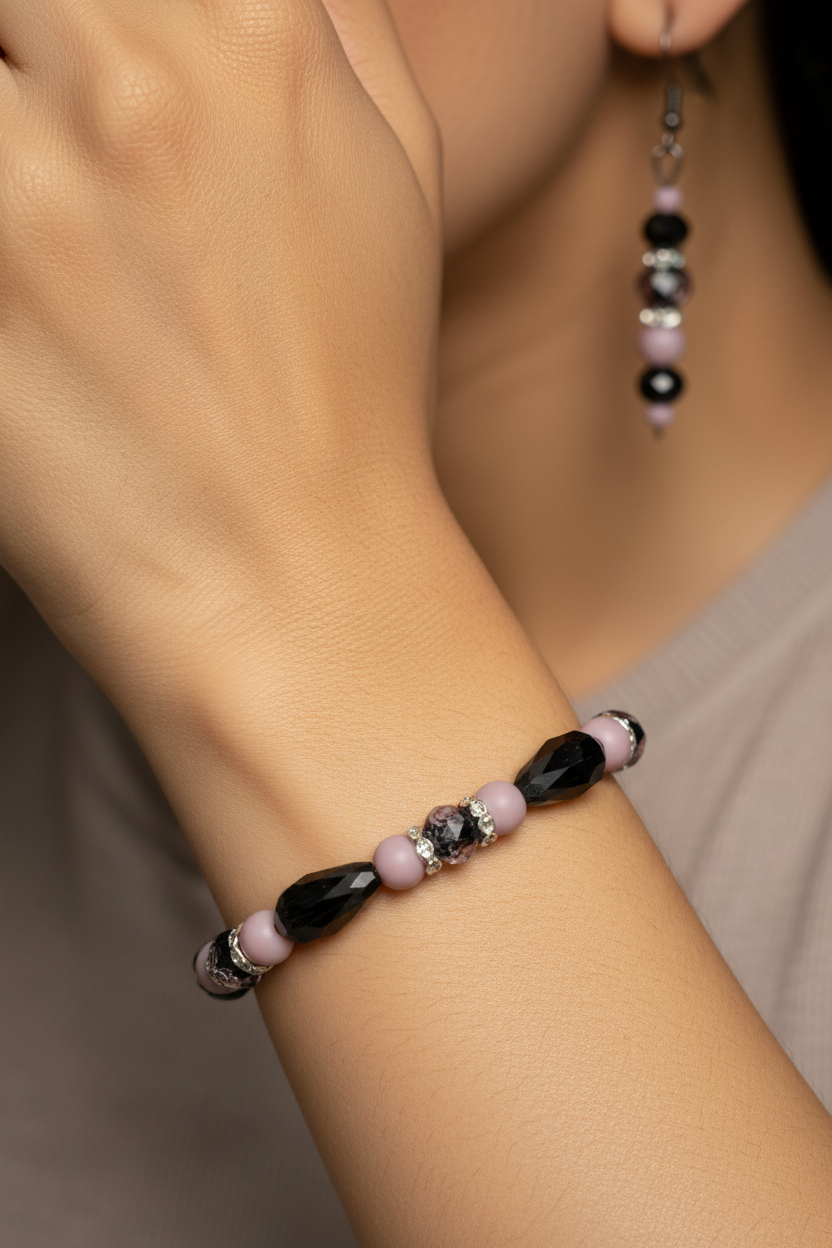 Close up of black crystal and pink bracelet and earrings on tan model